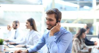 Servicemitarbeiter telefoniert mit einem Headset im Büro
