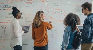 Mitarbeiterinnen und Mitarbeiter arbeiten mit einem großen Mindboard